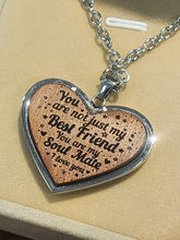 Load image into Gallery viewer, Heart-shaped wooden pendant with engraved text on a beige background
